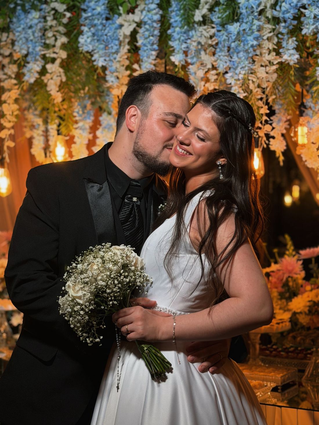 Casal abraçado sob cortina de flores