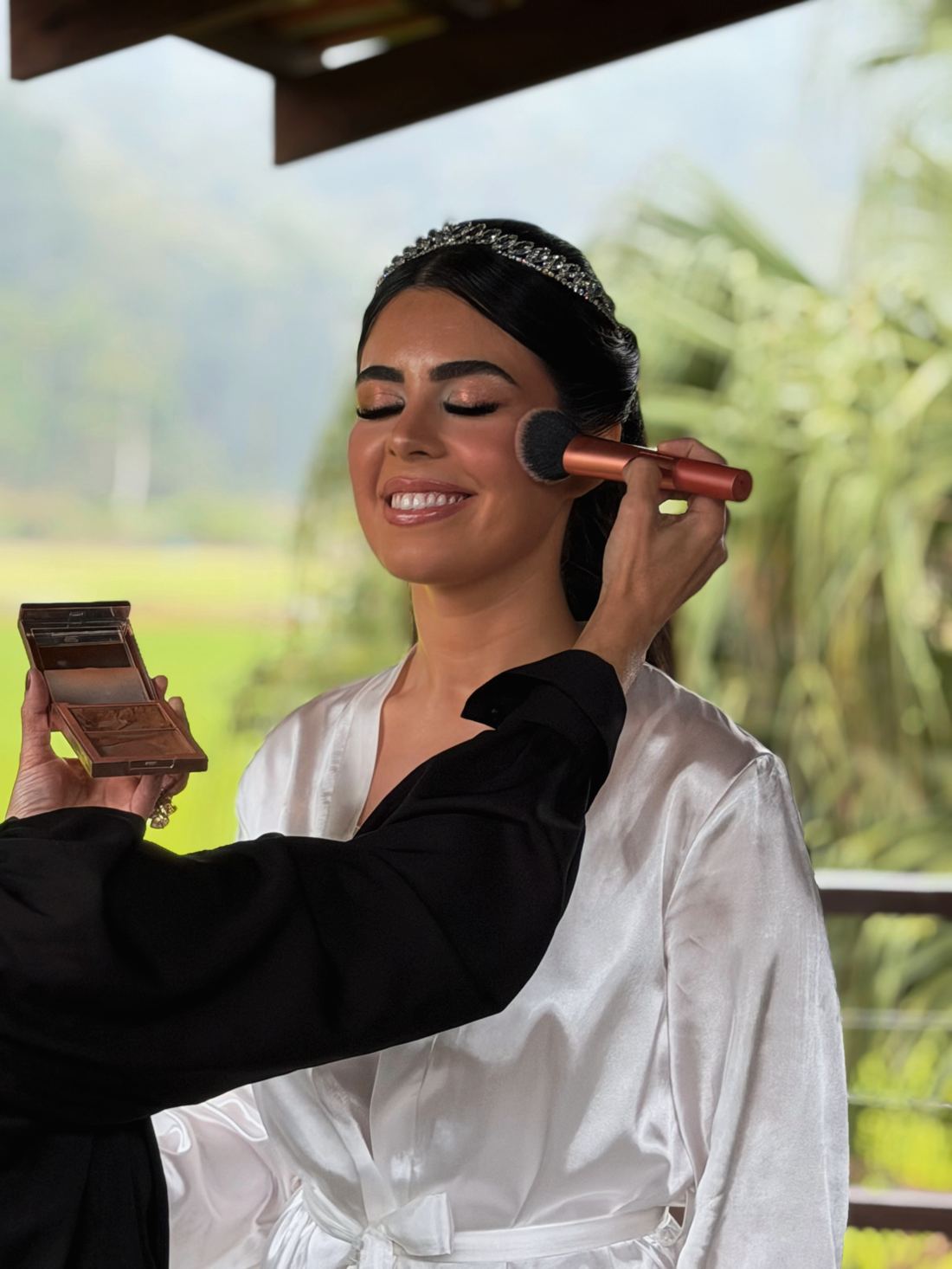 Noiva sorrindo durante a maquiagem